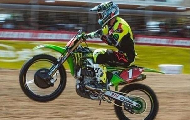 It looks like this motor-biker is grabbing his chin